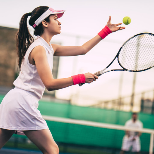 Young couple on tennis court. Handsome man and attractive woman are playing tennis.